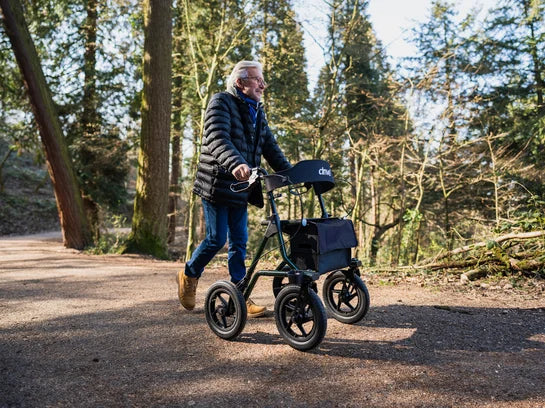 Drive Torro Outdoor rollator in a lifestyle setting with sturdy frame, large wheels, and comfortable seat for outdoor mobility.