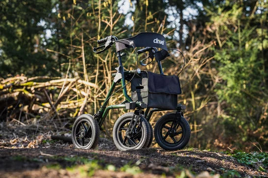 Green DRIVE Torro Outdoor Rollator with sturdy frame, large wheels, and comfortable seat for outdoor mobility support.